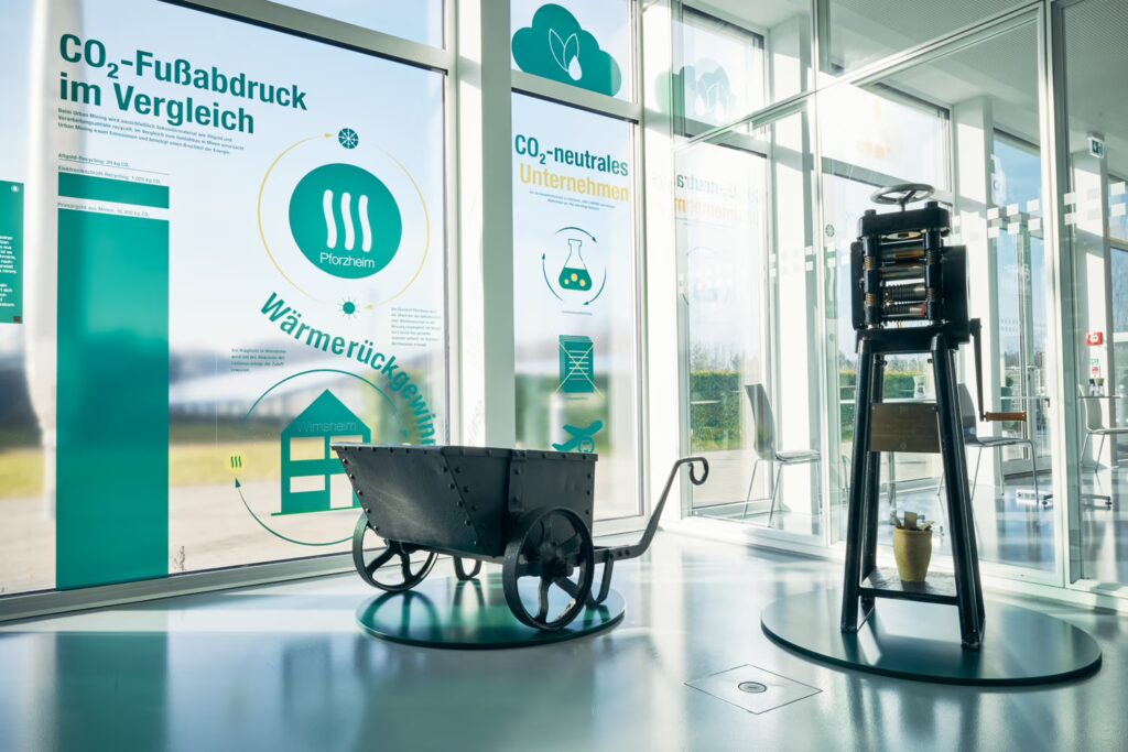 Zwei historische Ausstellungsobjekte in einem Ausstellungraum mit großen Glaswänden.