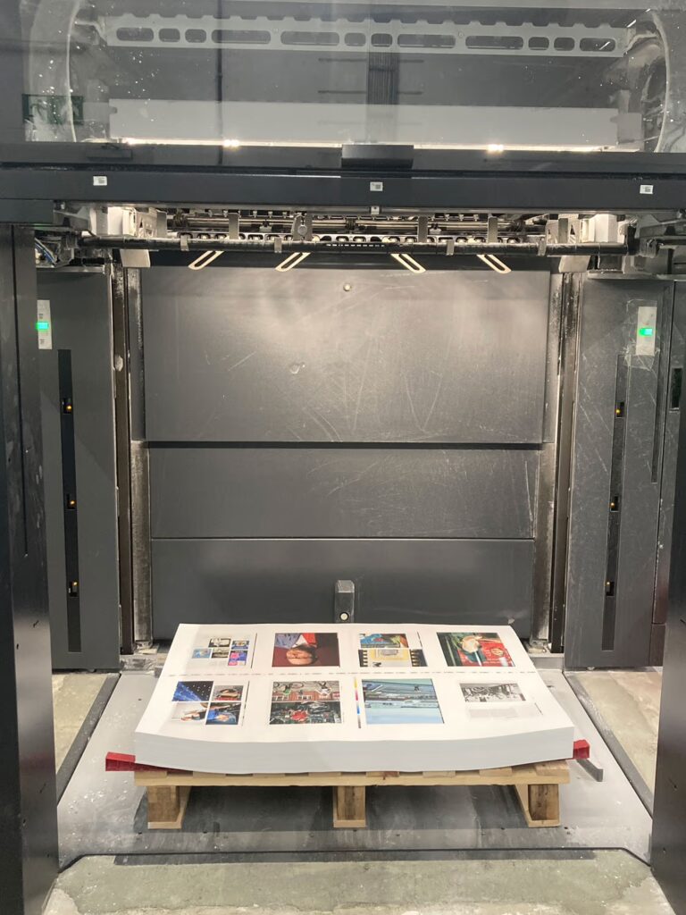 Ein Stapel mit Druckbögen liegt auf einer Euro-Palette auf dem Boden in einer Druckerei.