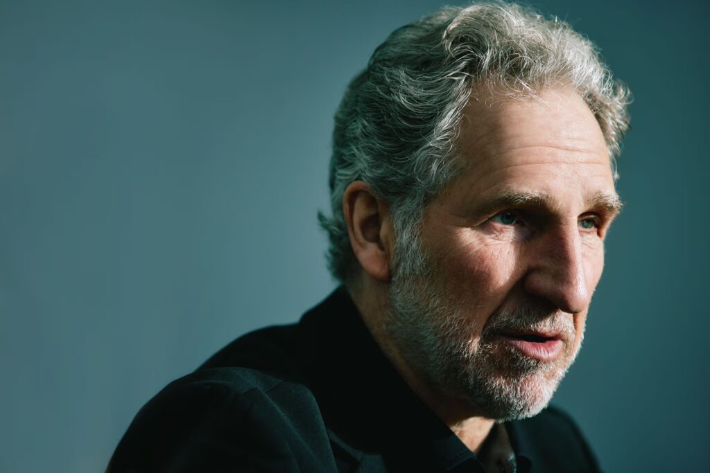 Porträtfoto eines grauhaarigen Mannes mit Bart. Es ist Andreas Enslin, Leiter des Design Centers bei Miele, während eines Interviews.