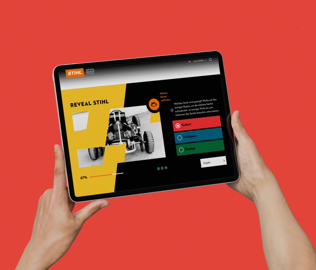 Zwei Hände halten das Display eines Tablets zur Kamera. Gezeigt wird eine STIHL-Webseite mit dem Titel Reveal Stihl. Der Hintergrund ist rot.