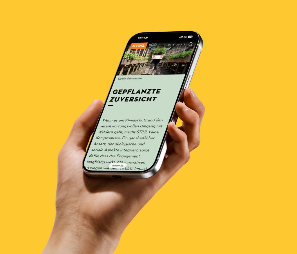 Eine Hand hält ein Smartphone mit Display zur Kamera, auf dem eine STIHL-Story mit dem Titel Geplanzte Zuversicht zu sehen ist. Der Hintergrund ist gelb.